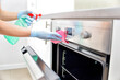 © Tomasz Warszewski - Woman in gloves cleaning kitchen.