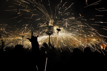 People playing with pyrotechnics in the street at a village. People having fun