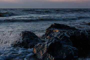 Wall Mural - rocks by the sea at sunset