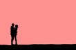 Pink valentine silhouette of a man and woman hugging each other on a hilly landscape