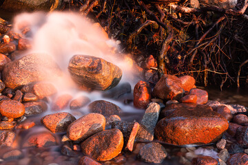 Wall Mural - stones at sea at sunset and in the long exposition