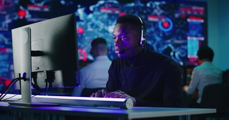Anxious African American programmer using computer at work