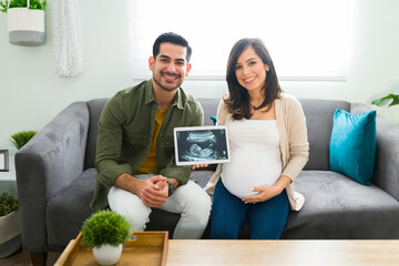 Wall Mural - Portrait of parents expecting a baby and holding their echography