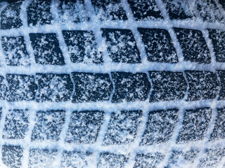 Car tire cowered with snow background. Closeup 