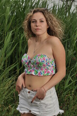 beautiful girl in a swimsuit and glasses on a background of beautiful greenery