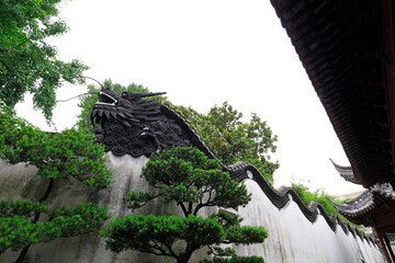 The sculpture of the dragon head is on the wall in Yu Garden, Shanghai, China