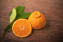 Orange Fruit On Wooden Table , Dekopon Orange Or Sumo Mandarin Tangerine With Leaves In Wooden Background.