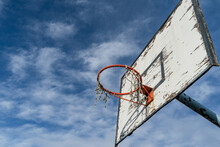 Low Angle View On The Devastated Table With Basket On The Basketball Court Against A Blue Sky With Clouds In Sunny Day