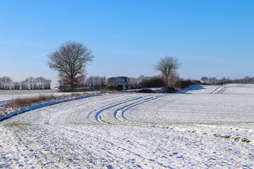 Sticker - Truck passing by a country road covered in snow on a sunny day in Germany