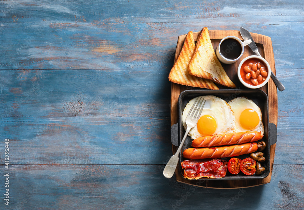 Traditional English breakfast with fried eggs on wooden background