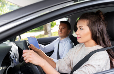 Wall Mural - driver courses, exam and people concept - young woman and driving school instructor with clipboard in car