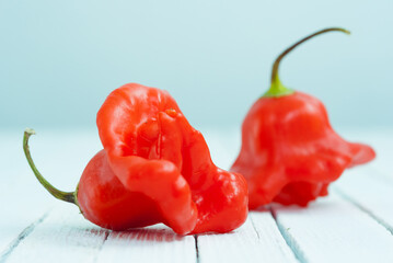 Wall Mural - chili on white wood table, side view