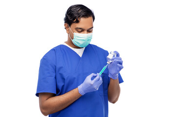 healthcare and vaccination concept - indian doctor or male nurse in blue uniform, face medical mask for protection from virus disease and gloves with syringe and medicine over white background