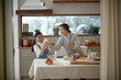 © stciel - Happy adorable little child girl in apron enjoying cooking homemade pastry together with grandmother at home.