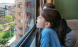 © David Pereiras - Two children in coronavirus lockdown playing breath on the glass as they look through the window