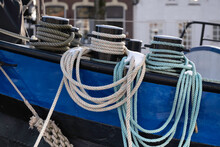 Thick Ship Ropes With Snow On Them Around The Bollards On The Bow Of A Moored Metal Freighter In Lemmer, The Netherlands. Focus On The Ropes. Small Depth Of Field 