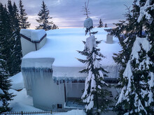 Small Modern Lodge Or Cabana Covered In Snow, Surrounded By Icy Evergreens Overlooking The Carpathian Mountains, Winter Landscape In Ranca, Romania