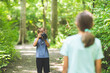 © digitalskillet1 - Young boy taking photo of his sister in the forest.