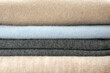 Stack of cashmere clothes as background, closeup