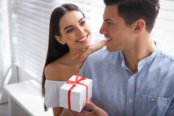 Sticker - Lovely couple with gift box at home. Valentine's day celebration