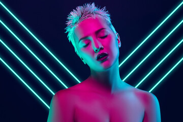 Future. Portrait of female fashion model in neon light with neoned blue glowing lines on dark studio background. Beautiful woman with trendy make-up and well-kept skin. Vivid style, beauty concept.