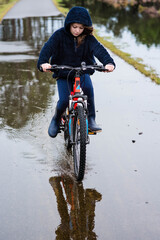 Wall Mural - beautiful young girl playing while rolling in puddles