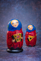 Matryoshka dolls in blue handkerchiefs, with an accordion, and a balalaika on a dark colorful background