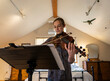 © Mint Images - Teenage girl playing her violin in her bedroom