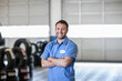 © Mint Images - Portrait of a smiling Caucasian male mechanic in an auto repair shop