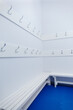 Photo of the locker room in the gym. Clothes hooks on a white wall
