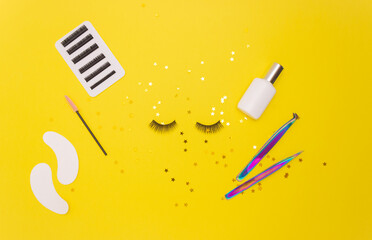 Wall Mural - Eyelash extension tools and artificial eyelashes on a yellow background. The view from the top.