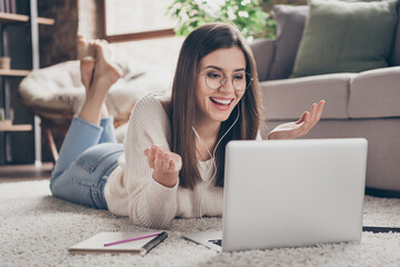 Poster - Full length photo of cheerful charming young woman talk web camera online seminar wear glasses earphones lie floor indoors in house