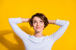 Photo portrait top above high angle view of woman looking up at blank space hands behind head isolated on bright yellow colored background