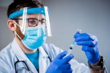 male doctor preparing to give coronavirus vaccine