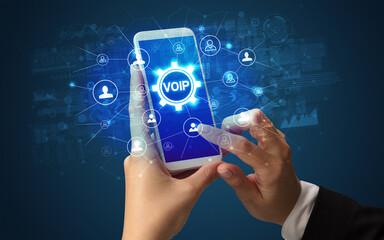 Poster - Female hand holding smartphone with VOIP abbreviation, modern technology concept