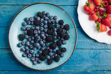 Sticker - Healthy breakfast eating a mix of fresh raw berries fruits