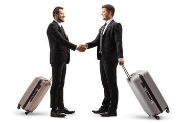 two young businessmen with suitcases shaking hands