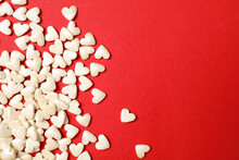 White Heart Shaped Sprinkles On Red Background, Flat Lay. Space For Text