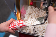 Scooping Popcorn Into A Bag From A Popcorn Machine
