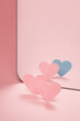 Coming out. Two pink paper hearts in front of a mirror. One heart is blue in reflected. Knowing yourself.