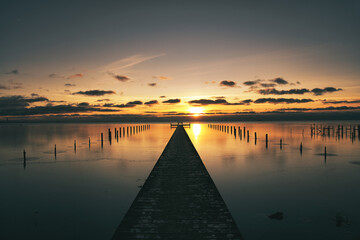 Wall Mural - Long wooden jetty over sea with sunset on the Swedish west coast.