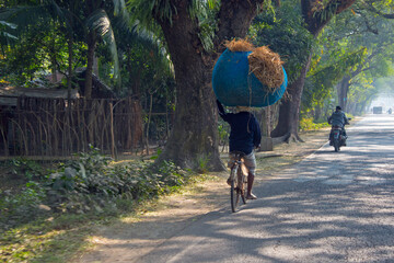 Sticker - Man riding a bicycle and carrying a large load on the head at the same time, Khulna Division, Bangladesh