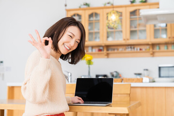 Wall Mural - 部屋でラップトップコンピューターを見る女性