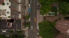 Top Down Overhead Aerial Shot Following A Yellow New York City Taxi Driving Through Residential Neighborhoods In The City