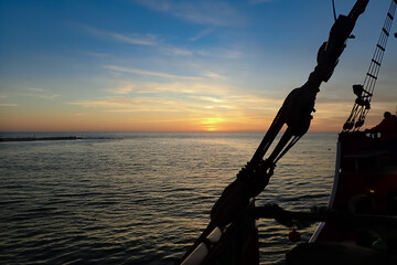 Wall Mural - Sailboat ropes silhouettes, sunset over the ocean 