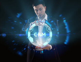 Business, Technology, Internet and network concept. Young businessman working on a virtual screen of the future and sees the inscription: CRM