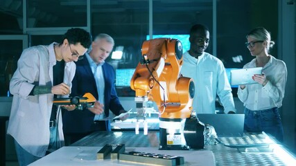 Wall Mural - team of researchers are holding an experiment with a robotic arm. professional engineers working at 