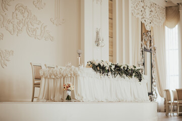 Luxurious, elegant wedding white table with floral centerpiece.