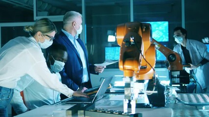 Wall Mural - researchers in face masks are talking in the robotics laboratory