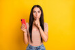 © deagreez - Photo portrait of young brunette holding mobile phone finger near lips secret isolated on bright yellow color background